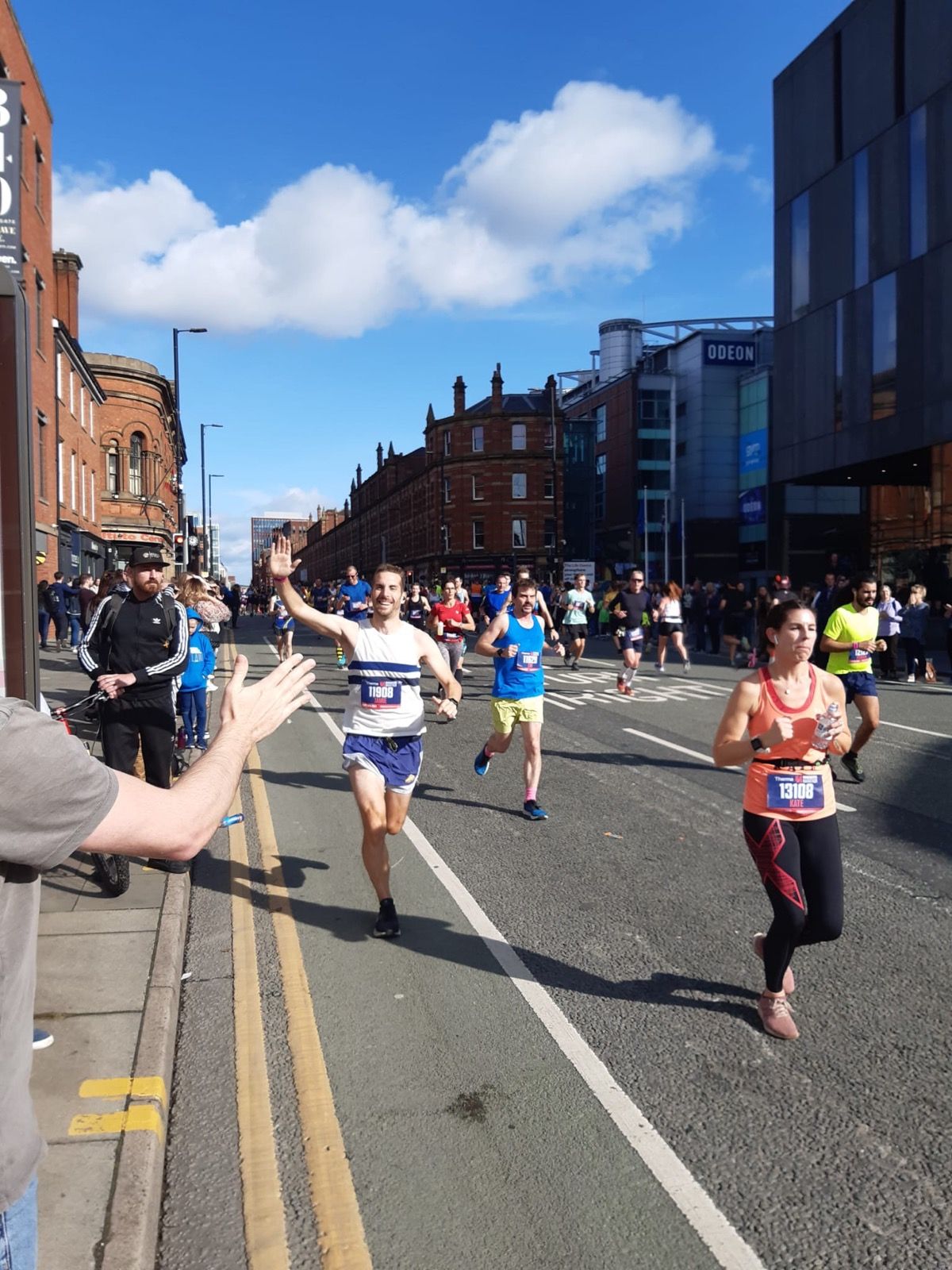 Jamie high-fiving a supporter while running a city marathon