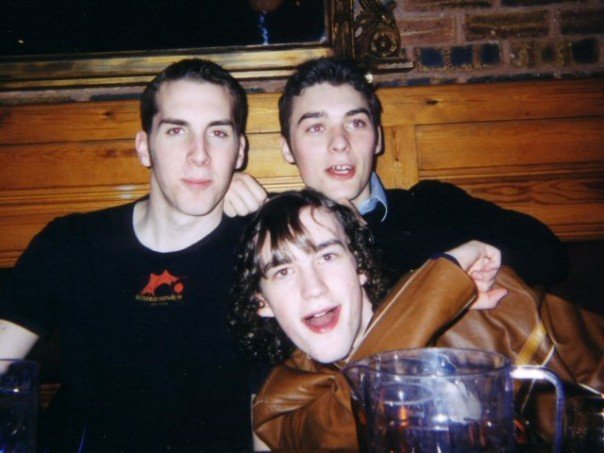 Three friends together in a pub with wooden panelling
